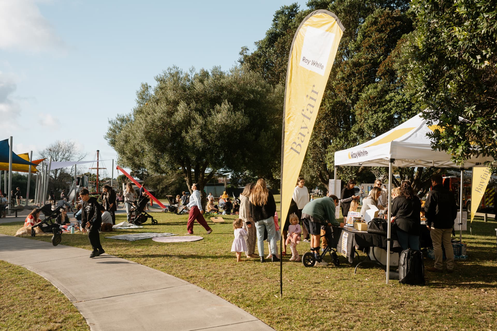 Ray White Bayfair community event in the park with families and a marquee