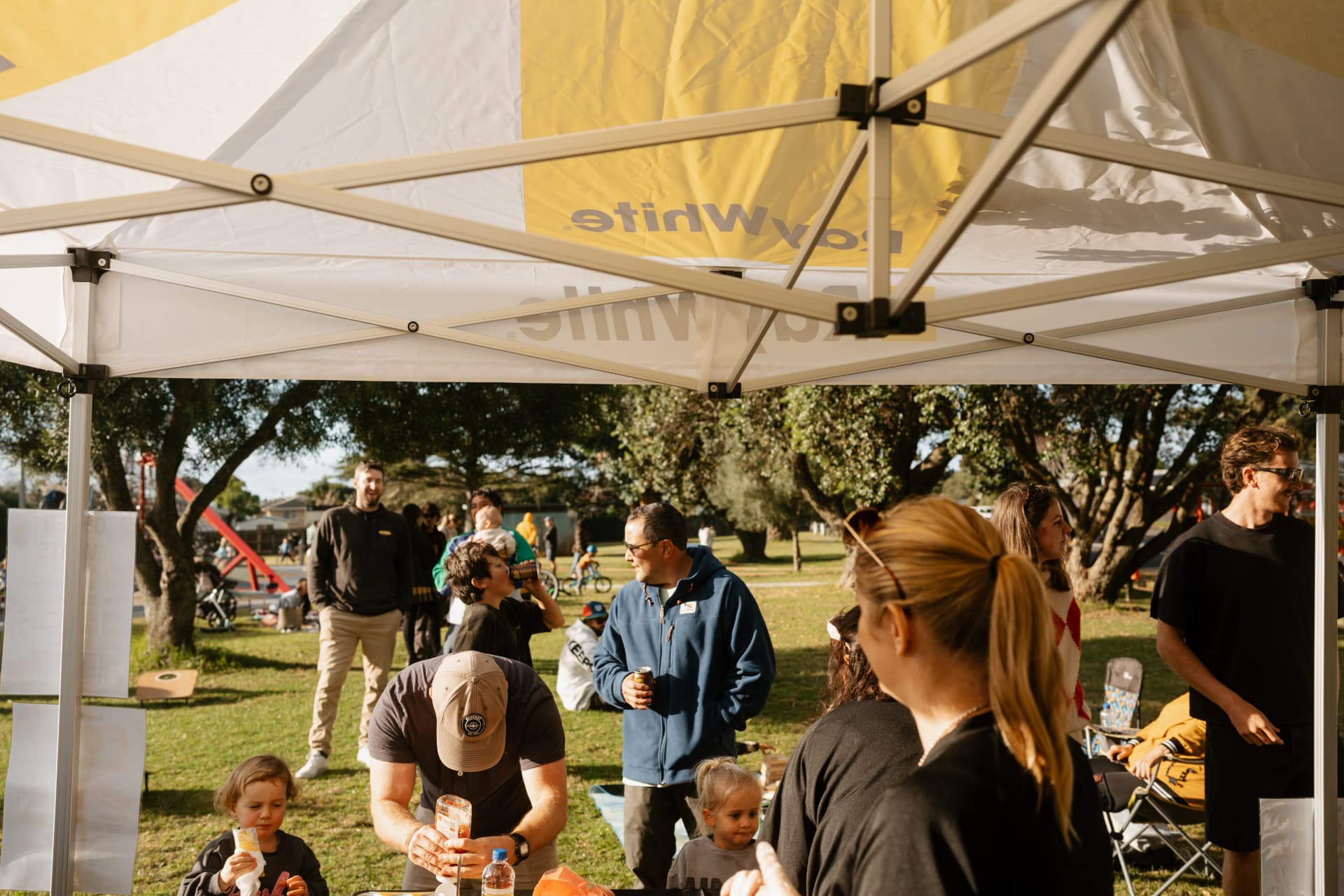 Community fundraising sausage sizzle under the Ray White marquee